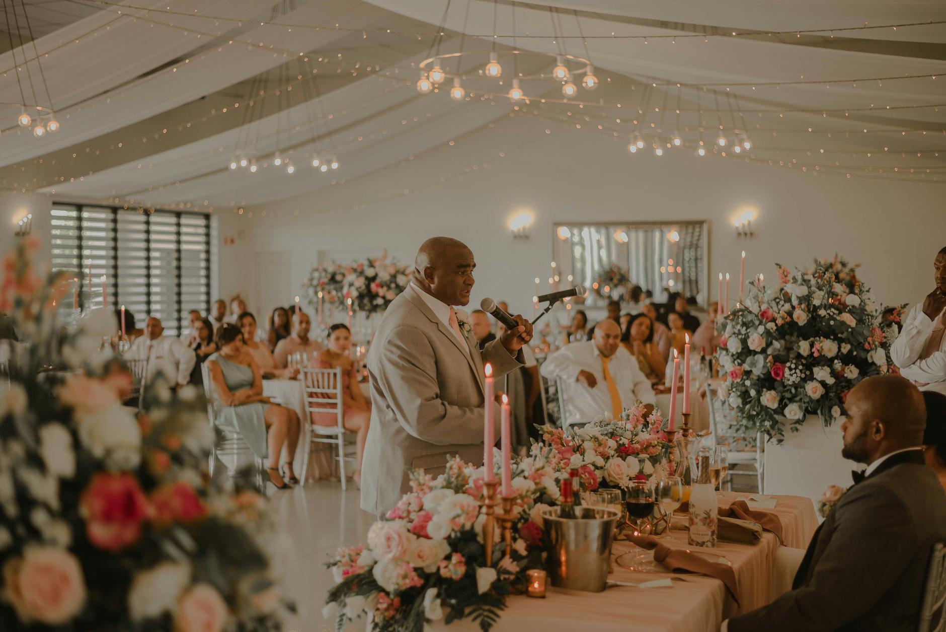 Goście na eleganckim przyjęciu ślubnym słuchają przemówienia