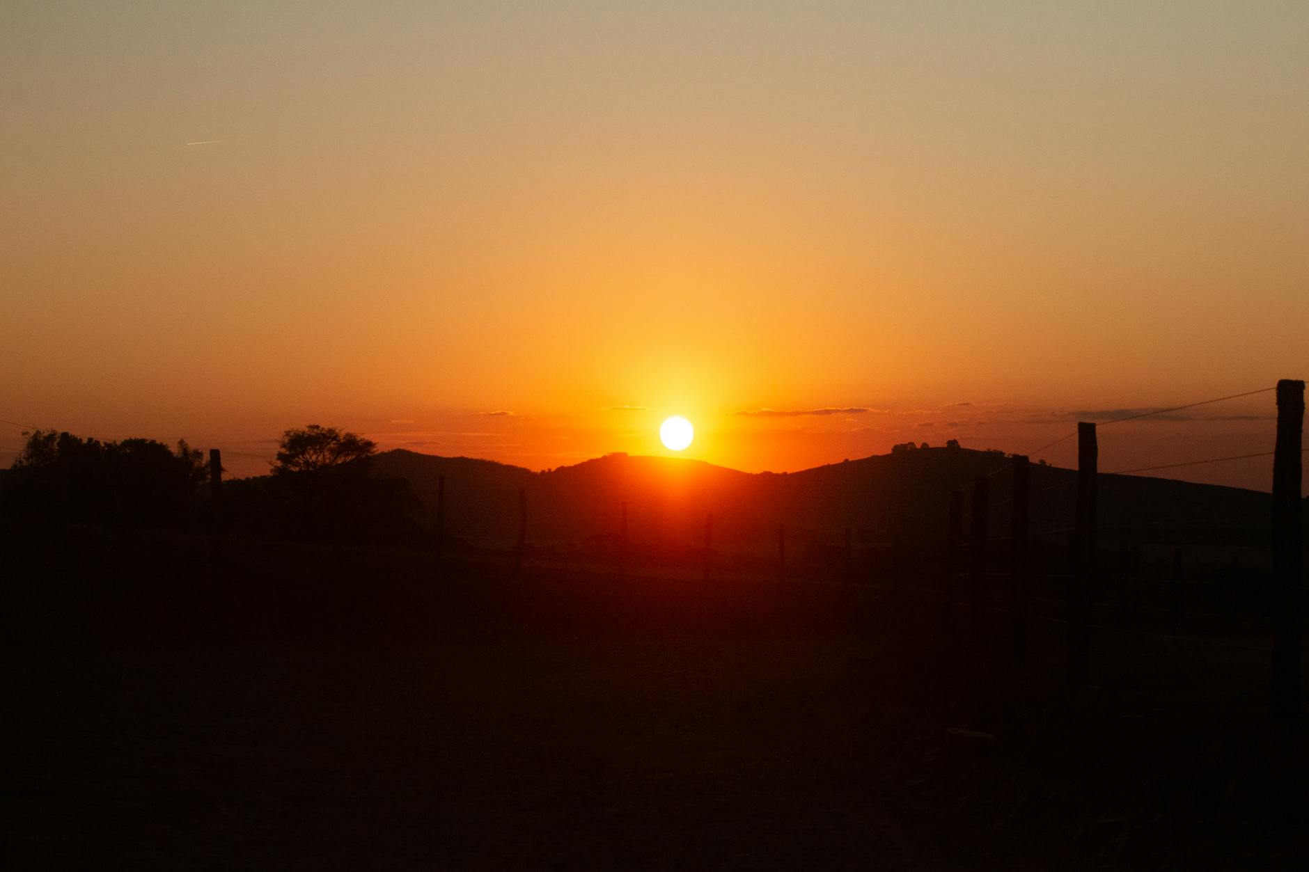 Zachód słońca nad pagórkami Wysoczyzny Elbląskiej i ciemnymi drzewami